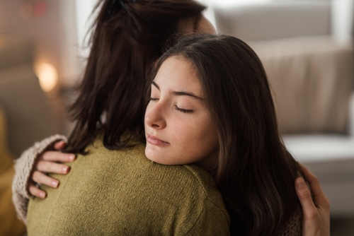 Teenage,Girl,Hugging,Her,Mother,At,Home.