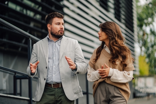 Two,Business,Partners,Having,A,Conversation,While,Walking,Outdoors,In